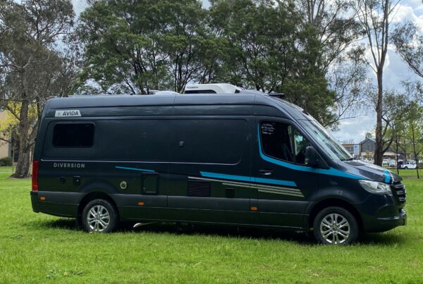 Avida Diversion campervan parked on grassy area, showcasing sleek design and outdoor lifestyle, reflecting freedom and adventure in motorhome travel.