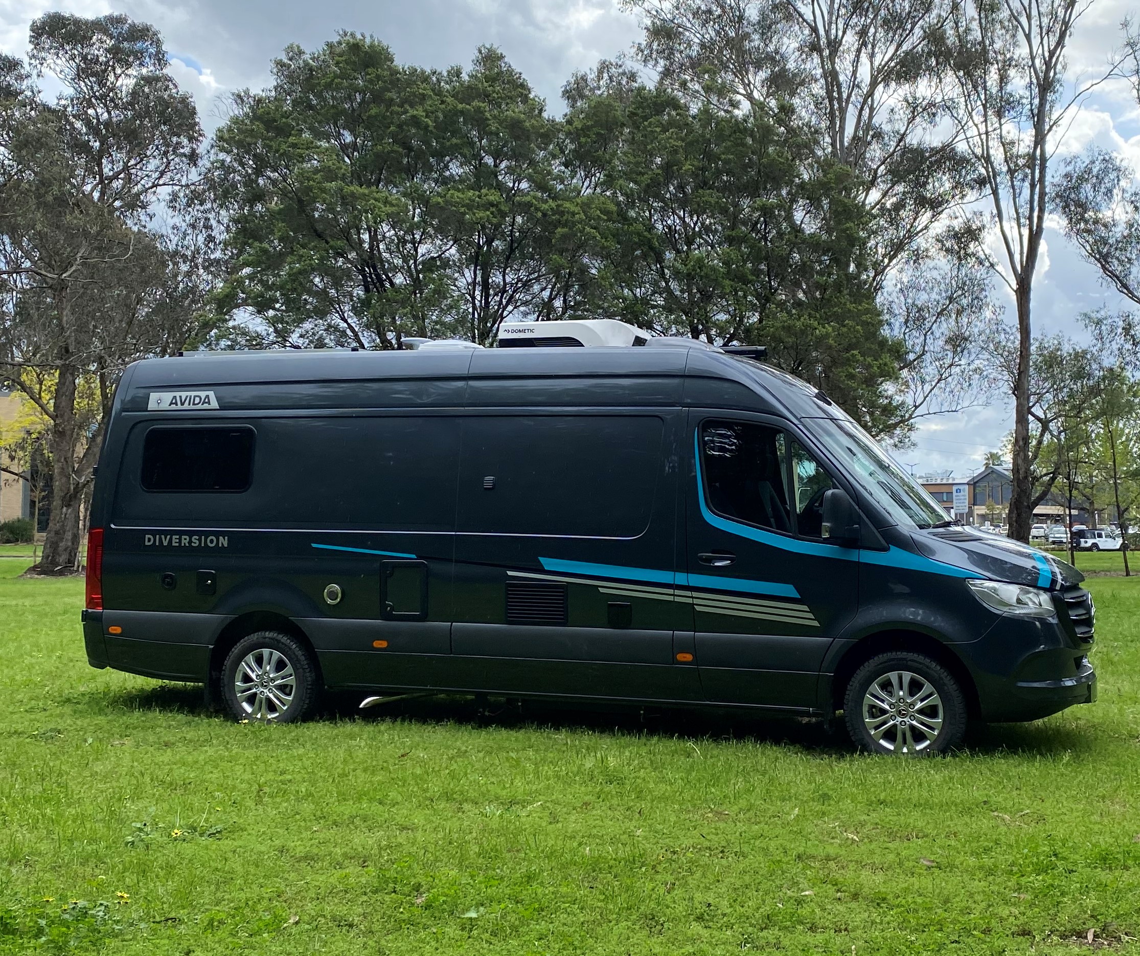 Avida Diversion campervan parked on grassy area, showcasing sleek design and functional features, relevant to optimizing storage and space for travelers.