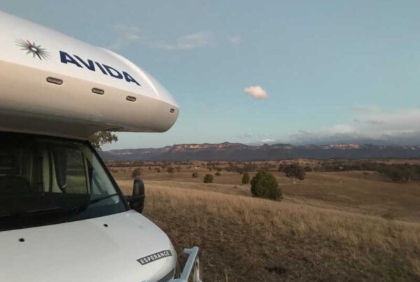 Avida campervan parked in scenic landscape with mountains in the background, highlighting freedom and adventure for travelers in Australia.