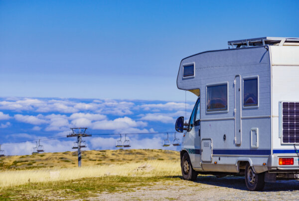 Motorhome parked above clouds with ski lift in the background, showcasing the adventurous spirit of exploring Australia's landscapes.