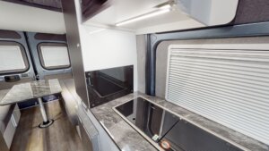 Modern Avida motorhome kitchen with sleek countertops, built-in stove, and ample storage, emphasizing full-time travel convenience and self-sufficiency.