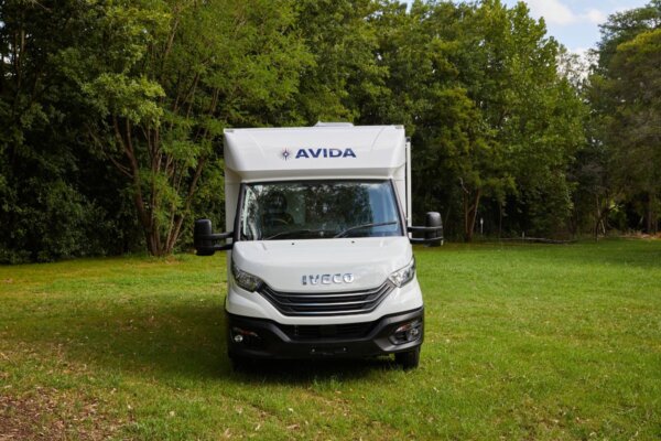 Avida Bruny motorhome front view on grassy terrain, showcasing the Iveco chassis and Avida branding, ideal for spacious and functional touring.