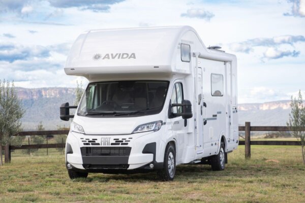 Avida Silverton motorhome parked on grassy terrain, showcasing a sleek design and Fiat Ducato chassis, ideal for outdoor living and travel adventures.