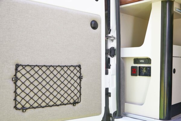 Interior detail of Avida Trek campervan showing storage net and control panel, highlighting smart design and optimized storage for compact living.